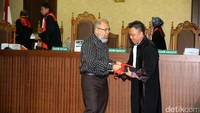 Patrialis berjabat tangan dengan kuasa hukumnya.