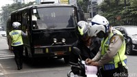 Pengendara sepeda motor yang terlanjur masuk tak bisa putar balik karena dibelakangnya melintas bus TransJakarta.