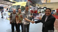 Marketing Director Sales and Marketing Division PT Krama Yudha Tiga Berlian Motors Duljatmono (jas hitam) menyerahkan dokumen kepada pembeli pertama Fuso FE 74 Long di sela-sela pameran Gaikindo Indonesia International Motor Show (GIIAS) 2017 di ICE BSD City, Tangerang.