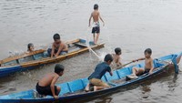 Foto: Mereka kemudian naik perahu kecil yang ada di tepian sungai. Dua perahu itu pun langsung penuh oleh anak-anak yang ceria ini (Kurnia/detikTravel)