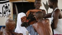 Salah seorang pemegang kurban akan meletakkan sebuah wadah untuk menampung darah (Akintunde Akinleye/Reuters)