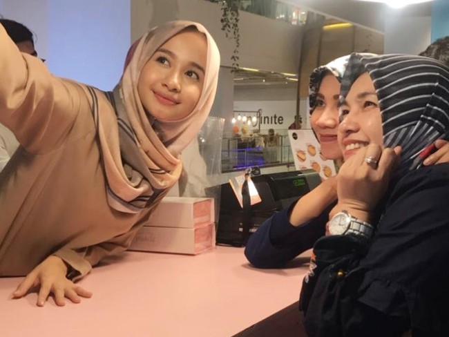 Ini penampilan Laudya Cynthia Bella yang menerapkan riasan natural saat foto bersama penggemar di bisnis kulinernya. Gaya hijab yang simpel membuat penampilan terlihat sederhana. (Foto: Dok. Instagram)