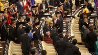 Presiden Jokowi dan Wapres JK berjalan menuju podium sambil melempar senyuman kepada anggota MPR.