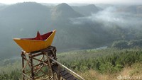 Spot foto berbentuk perahu kertas yang dicat kuning. Duduk di spot ini, traveler seakan diajak berperahu di atas lautan awan (Randy/detikTravel)