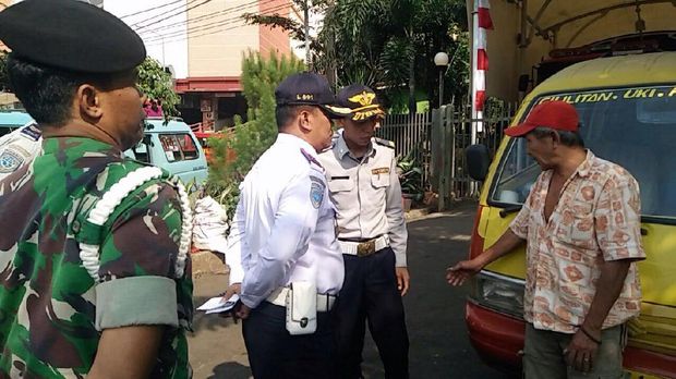 Selain parkir menutup jalur mobil pemadam kebakaran, angkot tersebut juga parkir di atas trotoar yang merupakan lokasi larangan parkir.