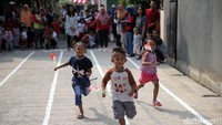Para balita lomba memasukan bendera ke dalam botol.