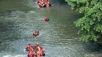 Mereka diiringi perenang yang mengawal secara body rafting/tubbing menuju jembatan Panus.