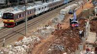 Commuter Line melintas di samping jalur DDT yang tengah digarap.
