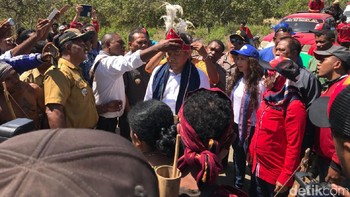 Saat tiba di Desa Tode, Menkominfo dipakaikan baju adat setempat. Foto: Adi Fida Rachman/detikINET