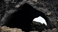 Setelah melewati kawah-kawah, traveler bisa lanjut jalan kaki sampai ke Dimmuborgir. Sebenarnya Dimmuborgir merupakan susunan bebatuan hitam dan gundukan vulkanik (menyerupai gua) yang terbentuk secara alami sejak 2.300 tahun yang lalu (Anita Isalska/BBC)