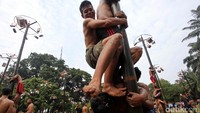Para peserta jatuh bangun untuk mencapai puncak bambu betung.