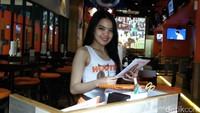 Di restoran tersebut para pelayan mengenakan tanktop putih bertuliskan Hooters dan rok pendek berwarna oranye.