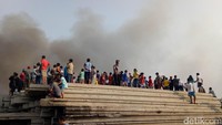 Warga menonton proses pemadaman kebakaran dari seberang sungai. Asap masih memenuhi lokasi / Foto: Muhammad Fida Ul Haq/detikcom