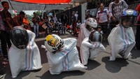 Sejumlah anak beradu cepat saat mengikuti lomba balap karung dengan mengenakan helm (Karung Race) di perumahan Persada Sayang, Kota Kediri, Jawa Timur, Minggu (20/8). Perlombaan unik itu menjadi favorit warga dalam memperingati HUT ke-72 RI. ANTARA FOTO/Prasetia Fauzani/pras/17