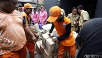 Para petugas PPSU menurunkan bantuan dari mobil boks untuk diserahkan kepada korban kebakaran.