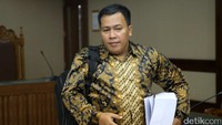 Marisi meninggalkan ruang sidang sambil membawa berkas tuntutan.