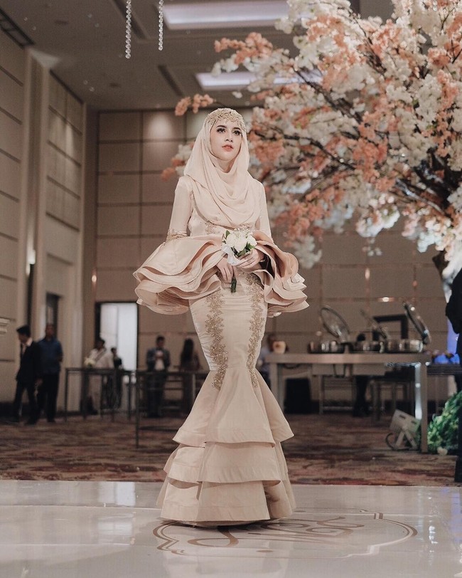Hijabers cantik yang juga turut hadir di pernikahan Medina Zein dan Lukman adalah Aghnia Punjabi. Penampilannya sungguh memesona dalam balutan gaun mermaid dengan potongan lengan ruffle yang cantik. Foto: Dok. Instagram