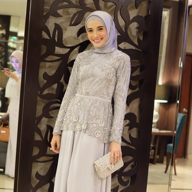 Zaskia Sungkar tampil anggun mengenakan gaun warna abu-abu yang penuh detail pada bagian atasnya ketika hadir di pernikahan Medina Zein dan Lukman. Ia melengkapi gaya glamour-nya dengan clutch berkilauan. Foto: Dok. Instagram