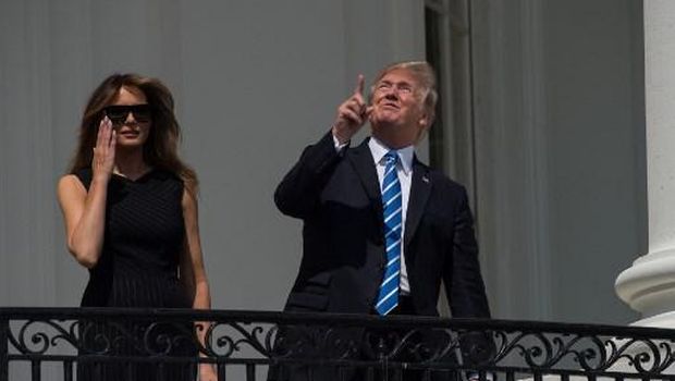 Trump juga menunjuk-nunjuk ke arah matahari, tanpa mengenakan kacamata.