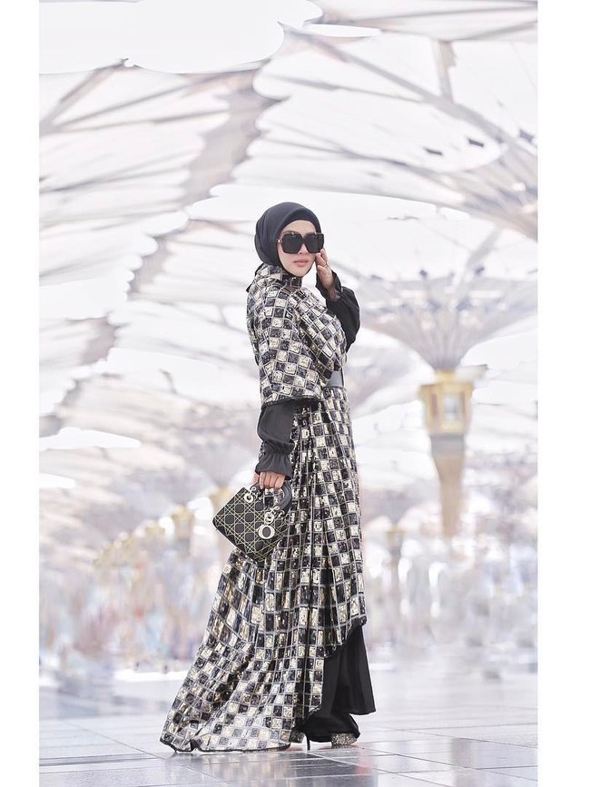 Giliran rancangan glamor Anniesa yang membungkus tubuh Syahrini. Terdiri dari gaun dan outerwear gelap nan mengilap, busana itu dipadu dengan tas Lady Dior yang ikonis itu. (Foto: Instagram)