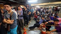 Kelelahan, para pengantre duduk tanpa alas.
