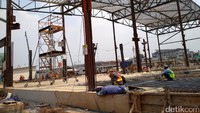 Para pekerja sedang membangun tempat untuk pencucian gerbong kereta.