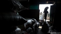 Pekerja saat mengumpulkan karungan beras ke dalam gudang.