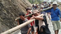 Warga ikut membantu membawa tiang listrik. (Dok. PLN)