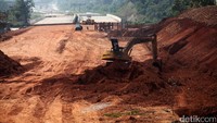 Ekskavator mengeruk lahan yang akan dijadikan tol Cijago seksi II.