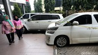 Warga yang akan melaporkan kasus First Travel melintas di depan mobil bos First Travel yang telah disita.