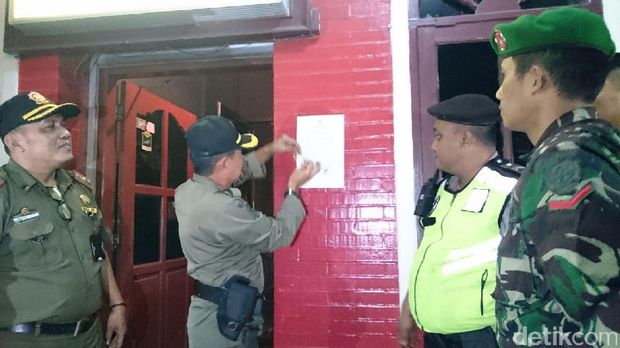Petugas menempel surat peringatan soal aturan buka tempat hiburan