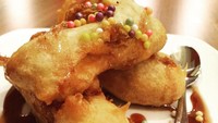 Pisang goreng dengan balutan tepung renyah dan kucuran cokelat leleh ini bisa jadi camilan. Juga bisa dipesan dengan tambahan es krim.Foto: Instagram: Nusa Dua London