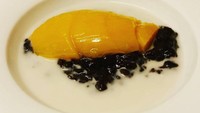 Dessert gaya Bali ini, bubur injin atau bubur ketan hitam disajikan dengan kuah santan dan irisan mangga arummanis yang legit.Foto: Instagram: Nusa Dua London