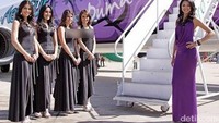  Busana pramugari Aeorsur Airlines dengan gaun panjang namun dengan kerah yang rendah membuat perempuan cantik ini terlihat mencolok.  