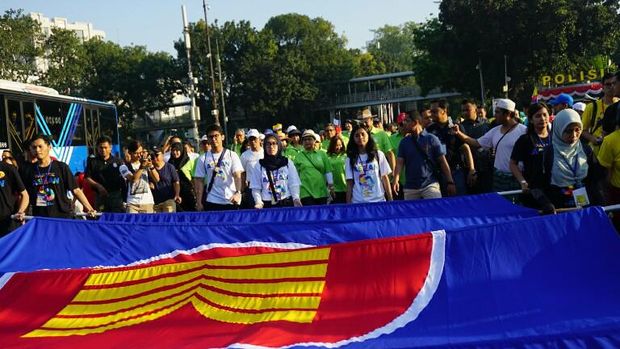 Peserta membawa bendera ASEAN
