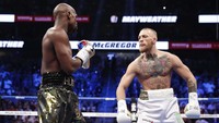 Duel ini terbilang sarat hiburan yang bisa bikin penonton mengulum senyum, salah satunya lewat aksi provokasi McGregor ini. (Foto: Steve Marcus/REUTERS)