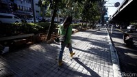 Seorang pekerja tengah melintas di atas proyek trotoar di kawasan Pulomas, Jakarta, Senin (28/8/2017).