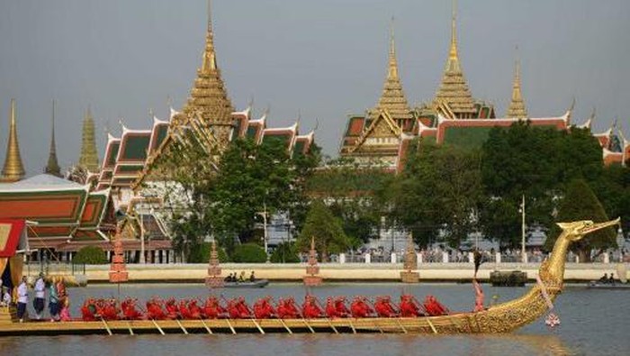 This picture taken on July 4, 2016 shows people taking a commuter boat on the Chao Praya River in Bangkok. / AFP PHOTO / LILLIAN SUWANRUMPHA
