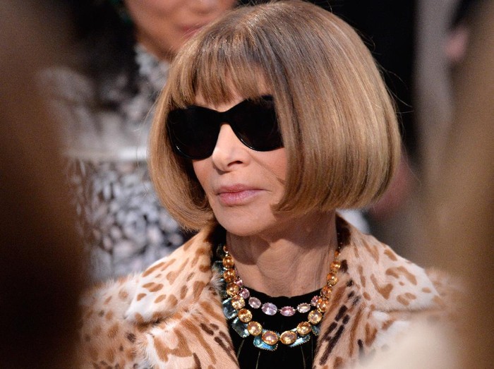 Ratu Elizabeth II & Anna Wintour LONDON, ENGLAND - FEBRUARY 20: Queen Elizabeth II sits next to Anna Wintour (R) and Caroline Rush, chief executive of the British Fashion Council (BFC) (L) as they view Richard Quinns runway show before presenting him with the inaugural Queen Elizabeth II Award for British Design as she visits London Fashion Weeks BFC Show Space on February 20, 2018 in London, United Kingdom. (Photo by Yui Mok - Pool/Getty Images)