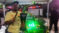 Farid, pemilik mobil menunjukkan penghargaan yang diterimanya.