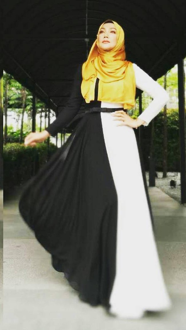 Pilihan warna monokrom dipadukan dengan jilbab gold membuat penampilan terlihat Erra Fazira terlihat feminin. Foto: Dok. Instagram @errafazira