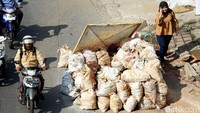 Warga melintas di sekitar proyek galian kabel.