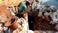 Seorang pekerja masuk ke dalam lubang untuk melakukan penggalian. Sementara pekerja lainnya menunggu di atas.
