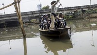 Perahu yang membawa pemotor melintasi sungai yang keruh dan terdapat sampah di berbagai penjuru/Foto: Antara Foto