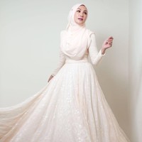 Erra Fazira terlihat anggun mengenakan gaun berpotongan rok flare warna putih gading. Gaya hijabnya tetap simpel dan elegan. Foto: Dok. Instagram @errafazira