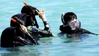 Sementara itu, turis lainnya masih asyik bersnorkeling ria. Ancaman rudal Korut nyatanya masih jauh dari Guam (Erik De Castro/Reuters)