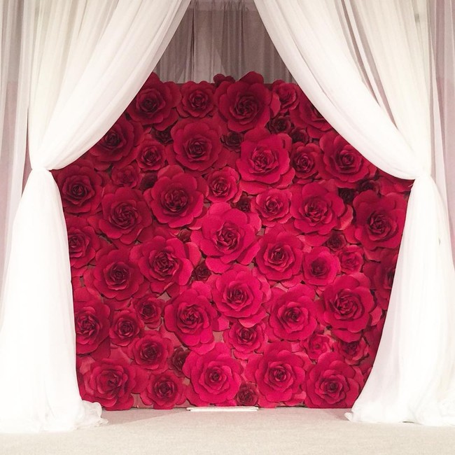 Ultra romantis, paper flower merah dengan aksen tirai ini juga patut jadi inspirasi dekorasi acaran lamaran dan pernikahan Anda. (Foto: Instagram thebluedahlia)