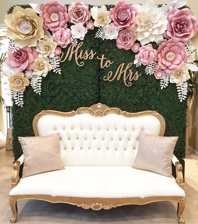 Tambahkan kursi mewah di depan backdrop paper flower seperti ini ketika berfoto dengan pasangan. (Foto: Instagram thebluedahlia)