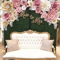Tambahkan kursi mewah di depan backdrop paper flower seperti ini ketika berfoto dengan pasangan. (Foto: Instagram thebluedahlia)