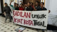 Warga membentangkan spanduk bertuliskan Keadilan untuk Rakyat Kota Tegal dan mendukung tindakan tangkap tangan oleh KPK. Mereka sengaja mencopot foto wali kota dan ditaruh di lantai (Imam Suripto/detikcom)